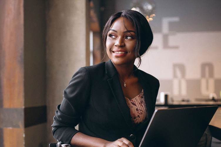 Picture of smiling young Black female using computer